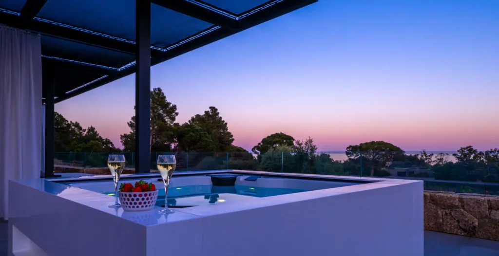 Le jacuzzi de l'Hôtel Villa Padulaccia au crépuscule, deux coupes posées sur le rebord