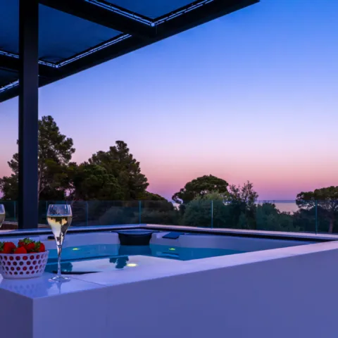 Le jacuzzi de l'Hôtel Villa Padulaccia au crépuscule, deux coupes posées sur le rebord