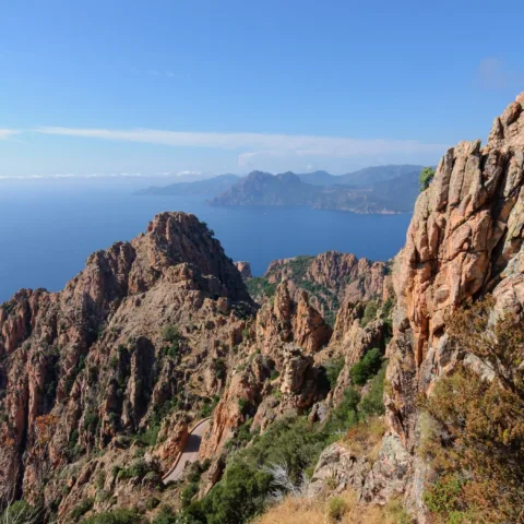 Les roches de granit rouge des Calanche de Piana dominant le golfe de Porto, route en contrebas.