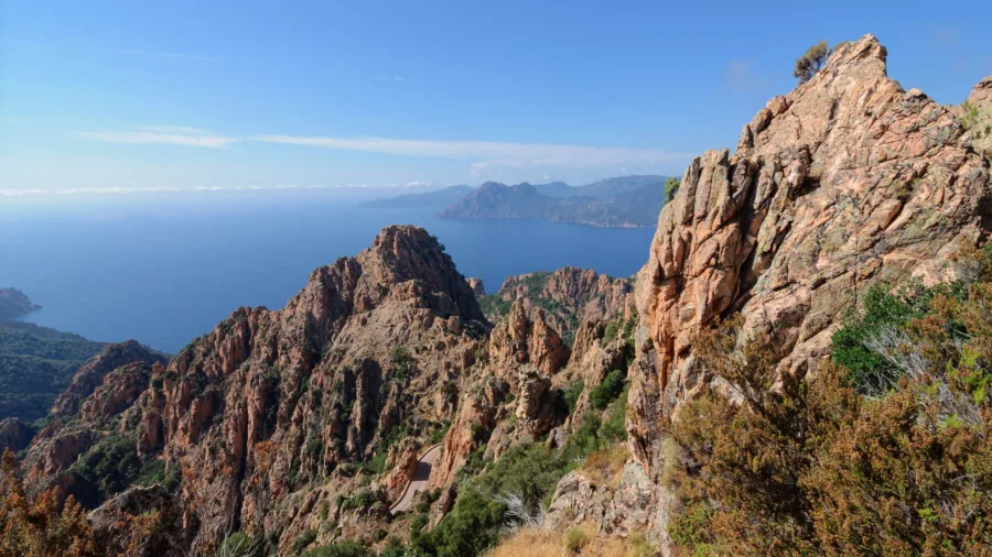 Les roches de granit rouge des Calanche de Piana dominant le golfe de Porto, route en contrebas.