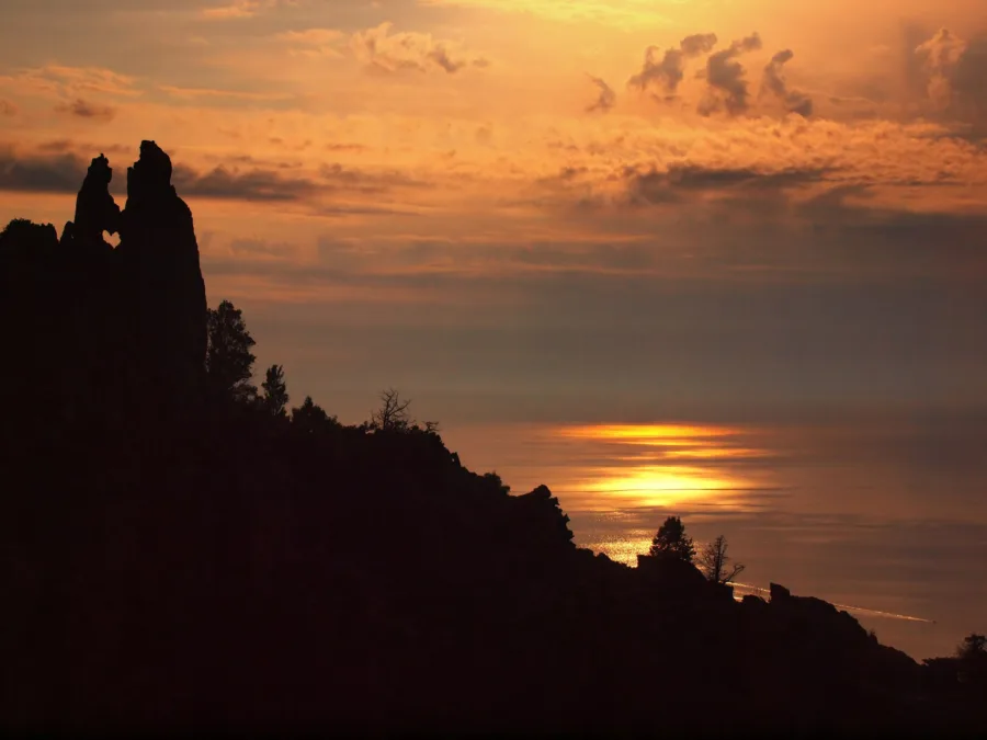 Coucher de soleil sur le golfe de Porto ; à gauche en silhouette, le rocher dit « des Amoureux » des Calanche de Piana.